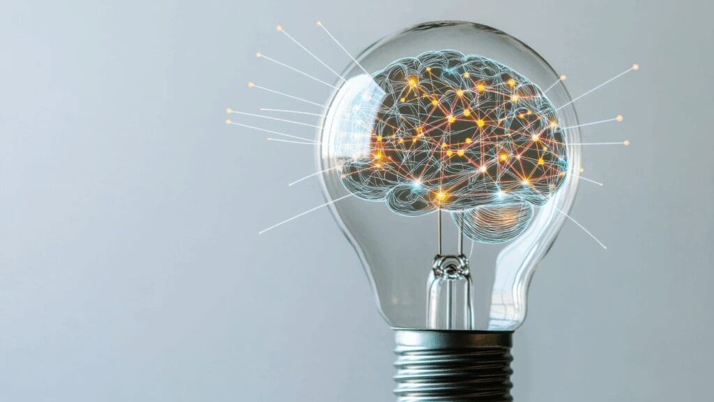 Illuminated brain network inside lightbulb representing breakthrough insights in life coaching vs neuroscience coaching transformation