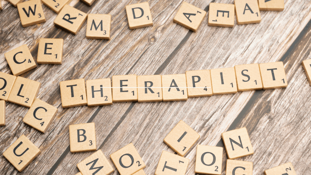 Scrabble tiles spelling therapist representing neuroscience coach vs therapist comparison