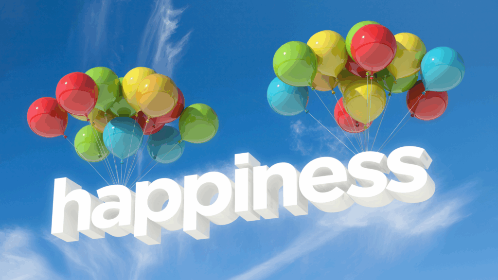 Multicolored balloons floating against a blue sky carrying the word "happiness," symbolizing the elevated mood from neuroscience of happiness research.