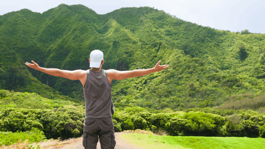 Man with arms outstretched in natural mountain landscape, expressing freedom and vitality achieved through dopamine reset supported by neuroscience-based approaches and outdoor movement.


