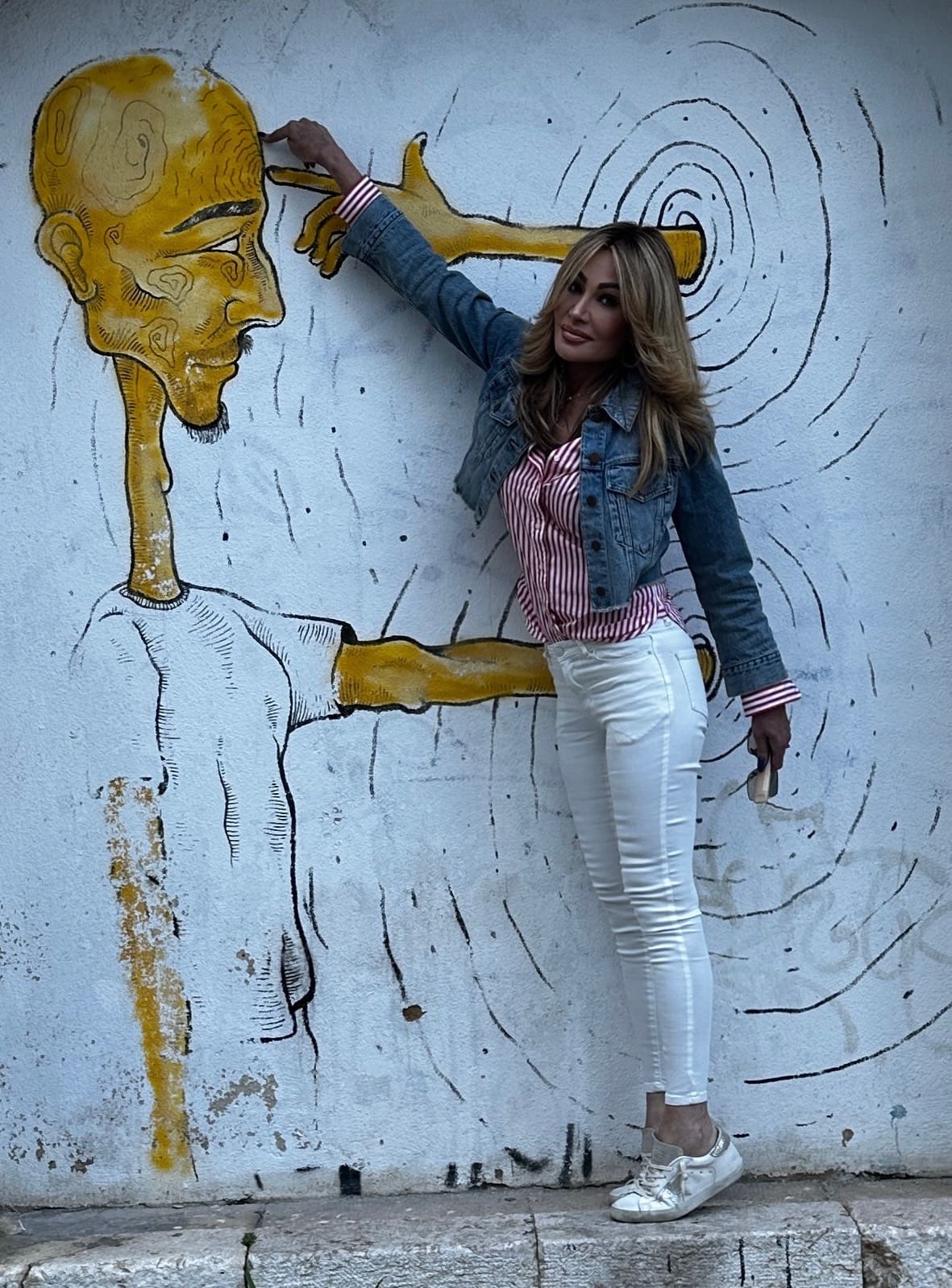 Dr. Sydney Ceruto interacting with street art in Bairro Alto Lisbon showing creativity and neural expansion