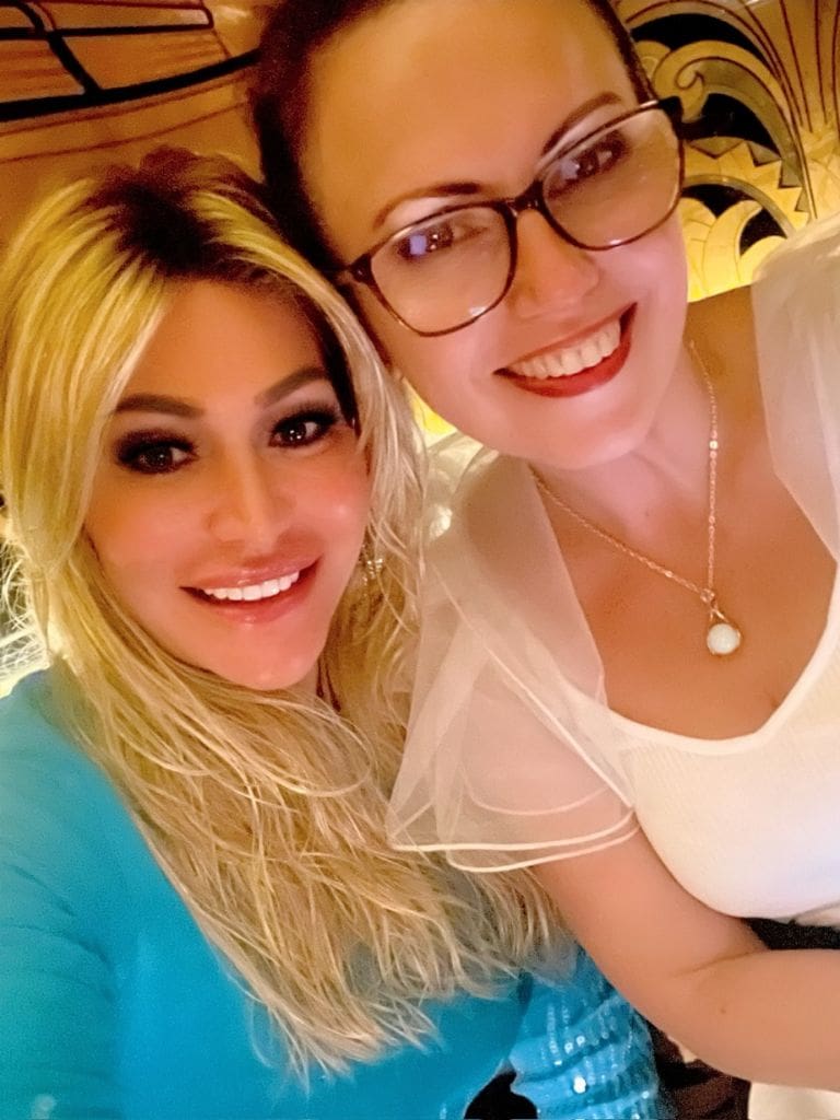 Dr. Sydney Ceruto smiling warmly in a selfie with a close friend during an evening dinner out